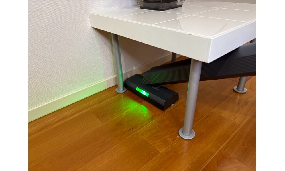 極吸ヘッドが家具の下のすき間まで入り込んでいるところ