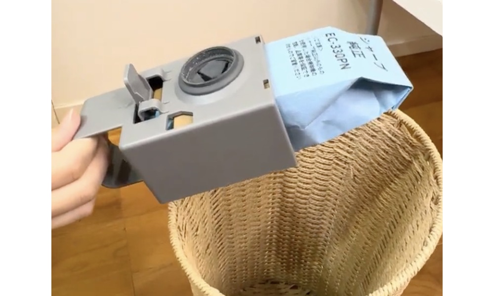 紙パックを取り外してゴミを捨てる様子